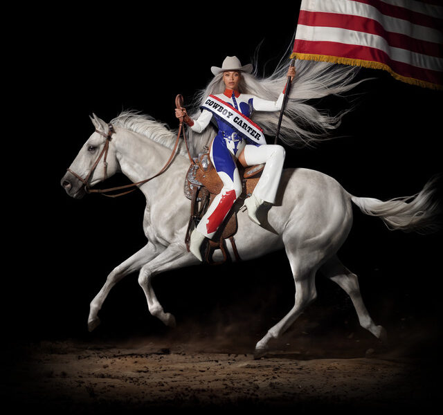 Capa do álbum premiado de Beyoncé, com a cantora montada sobre um cavalo branco com as pernas viradas para frente, vestimentas remetendo à bandeira dos Estados Unidos e um chapéu branco de caubói, segurando a bandeira do país sobre um fundo preto.